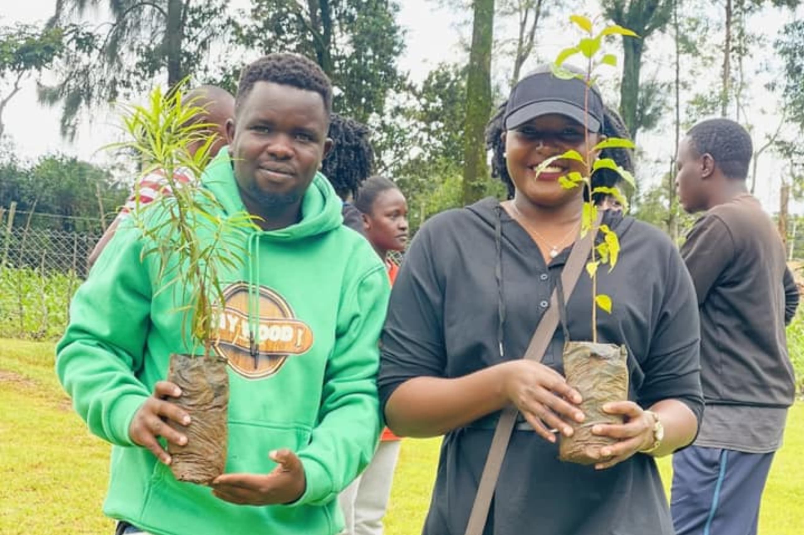 A man and a lady each carrying seedlings